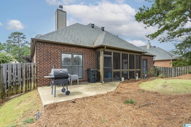 rear view of house featuring a sunroom and a patio area