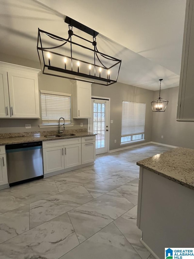 kitchen featuring white cabinetry, sink, hanging light fixtures, stainless steel dishwasher, and light stone countertops