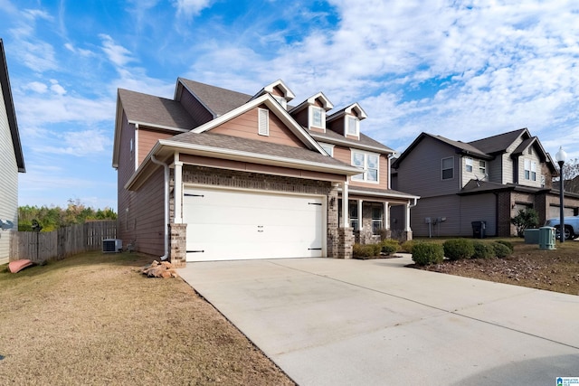 craftsman inspired home featuring brick siding, concrete driveway, fence, a garage, and a residential view