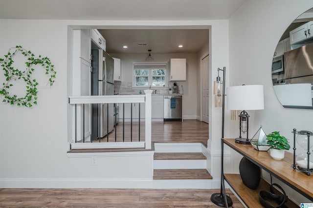 interior space featuring white cabinetry, decorative backsplash, dark hardwood / wood-style flooring, and appliances with stainless steel finishes