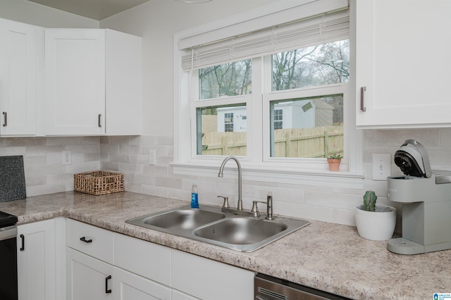 kitchen with white cabinetry, sink, and decorative backsplash