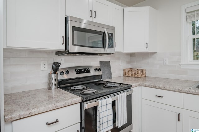 kitchen with white cabinetry, tasteful backsplash, and appliances with stainless steel finishes