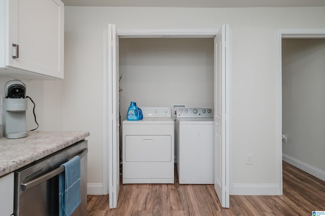 clothes washing area featuring separate washer and dryer and light hardwood / wood-style flooring