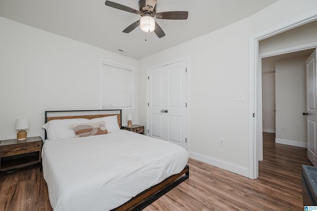 bedroom featuring hardwood / wood-style flooring, ceiling fan, and a closet