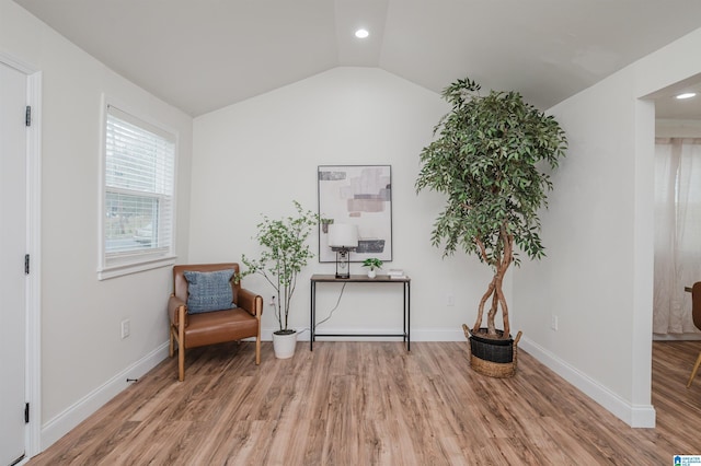 sitting room with hardwood / wood-style floors and vaulted ceiling