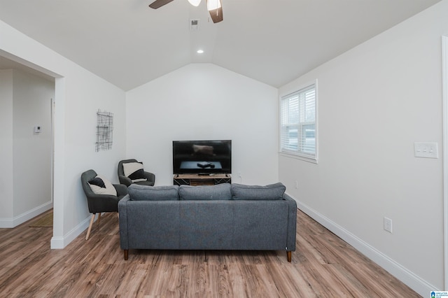 living room with hardwood / wood-style floors, vaulted ceiling, and ceiling fan