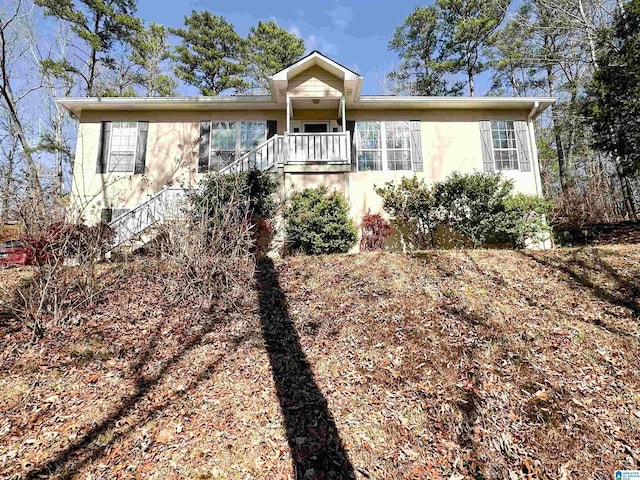 single story home with stairway and stucco siding