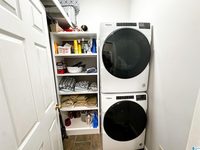 washroom with laundry area, dark wood-type flooring, and stacked washer / drying machine