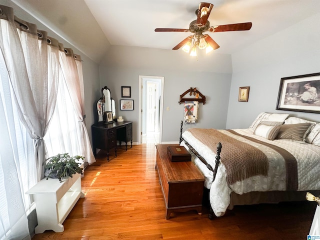 bedroom featuring a ceiling fan, vaulted ceiling, and light wood-style flooring