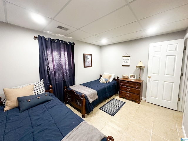 bedroom with light tile patterned floors, a paneled ceiling, and visible vents