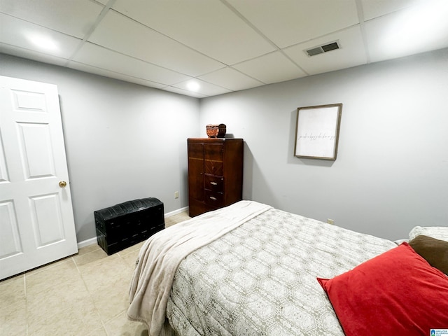 bedroom featuring a paneled ceiling, tile patterned floors, visible vents, and baseboards