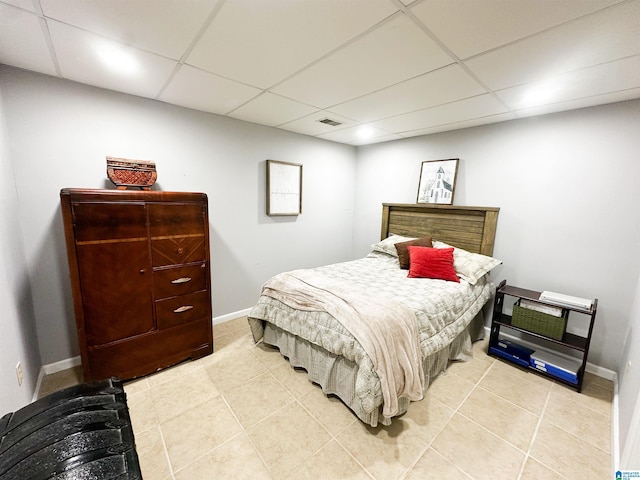 bedroom featuring a paneled ceiling, visible vents, and baseboards