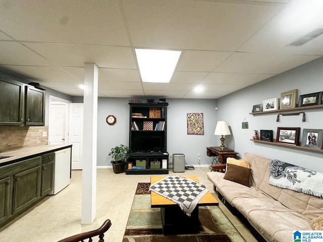 living area featuring light floors, a paneled ceiling, visible vents, and baseboards