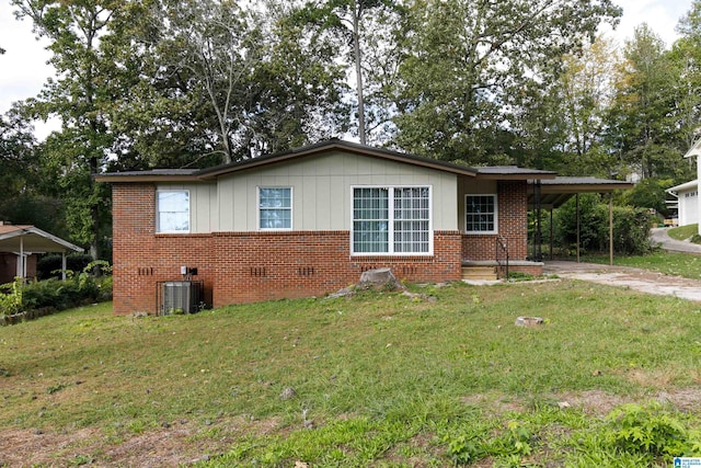 view of front facade with a carport, central AC unit, and a front yard