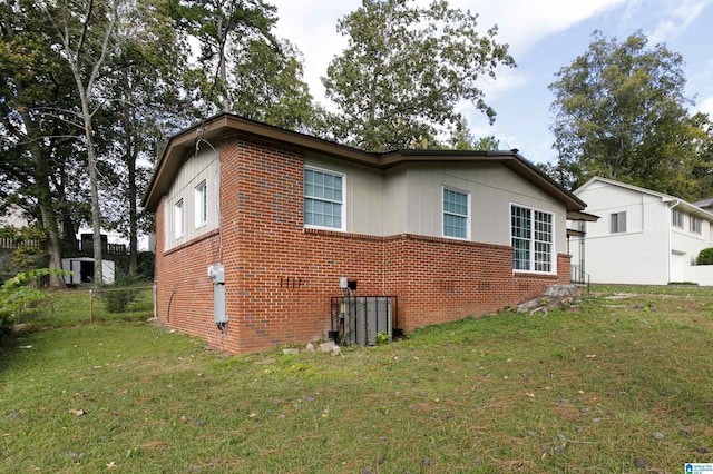 view of property exterior with central AC unit and a lawn