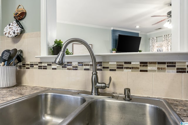 room details with tasteful backsplash, dark countertops, ornamental molding, a sink, and ceiling fan