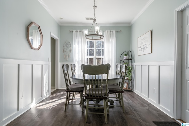 dining space with ornamental molding, visible vents, dark wood finished floors, and a decorative wall