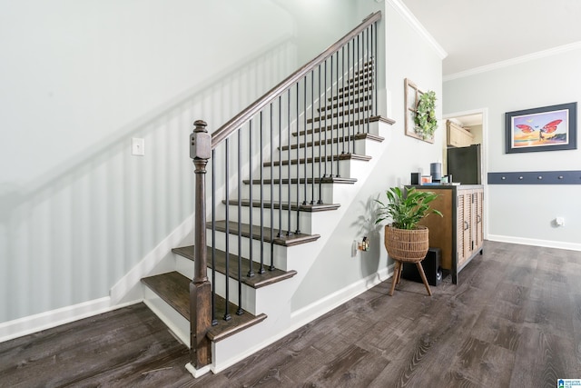 stairway with ornamental molding, baseboards, and wood finished floors