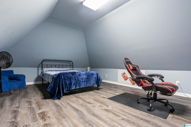 bedroom with lofted ceiling, wood finished floors, and baseboards