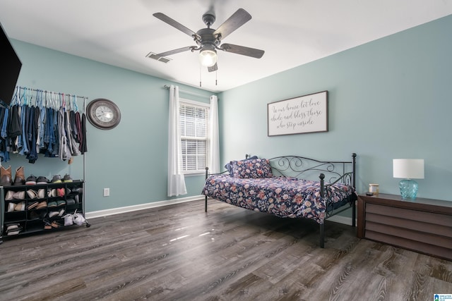 bedroom featuring dark wood-style floors, visible vents, ceiling fan, and baseboards