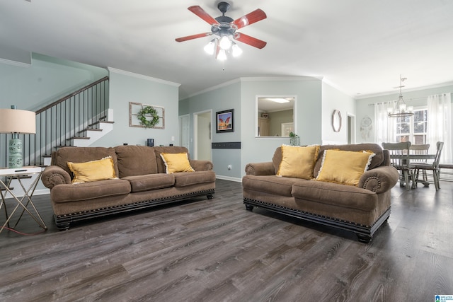 living room with dark wood-style floors, ceiling fan with notable chandelier, crown molding, and stairs