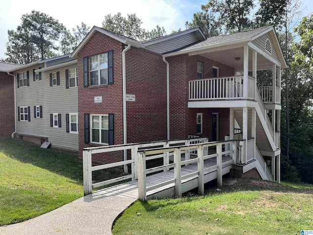 view of front of home with a balcony and a front yard