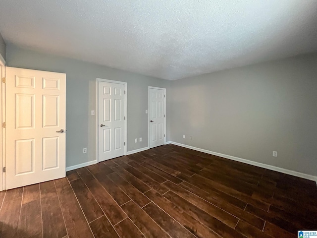 interior space with dark wood-type flooring and a textured ceiling