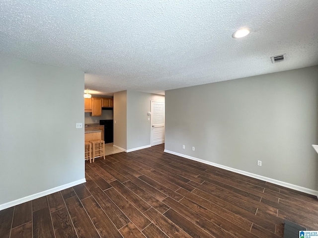 unfurnished living room with dark wood-type flooring and a textured ceiling