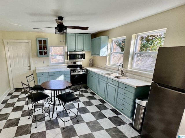 kitchen with appliances with stainless steel finishes, sink, and ceiling fan