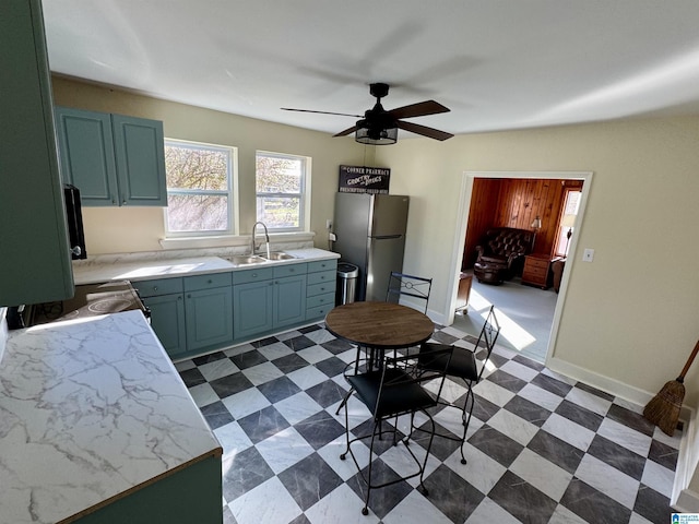 kitchen featuring ceiling fan, stainless steel fridge, and sink