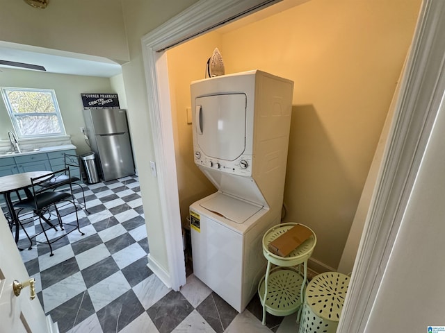 laundry room featuring stacked washing maching and dryer and sink