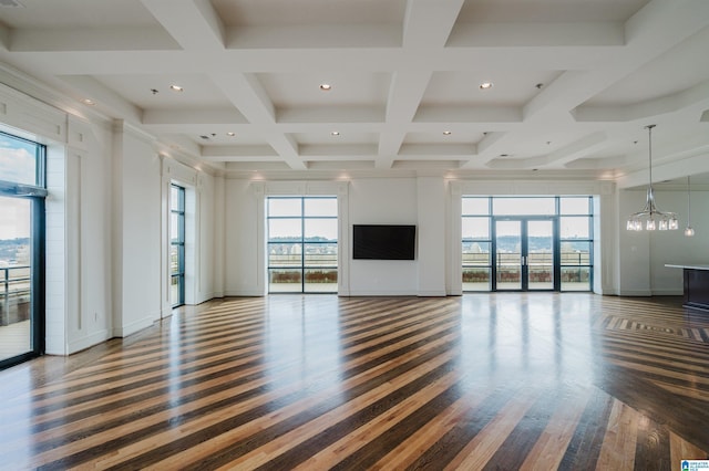 unfurnished living room featuring coffered ceiling, dark hardwood / wood-style floors, a wealth of natural light, and beam ceiling