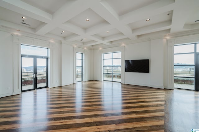 unfurnished living room featuring beamed ceiling, plenty of natural light, dark wood-type flooring, and french doors