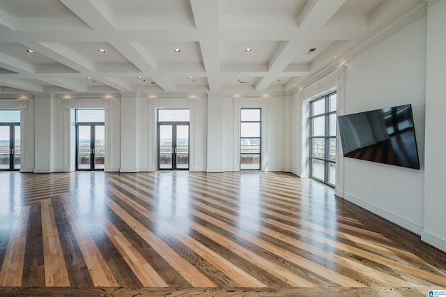 unfurnished living room with beam ceiling, hardwood / wood-style flooring, a high ceiling, french doors, and coffered ceiling