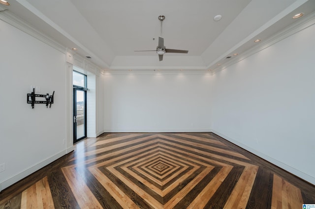 spare room featuring crown molding, parquet floors, ceiling fan, and a raised ceiling