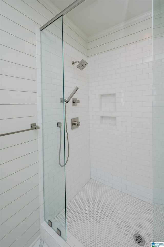 bathroom with crown molding and a tile shower