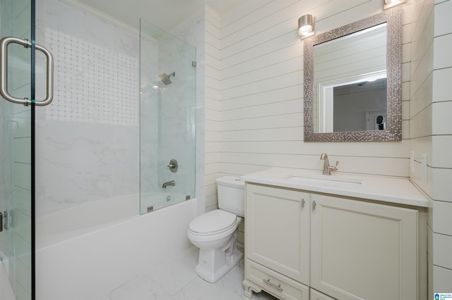 full bathroom with wooden walls, vanity, combined bath / shower with glass door, and toilet