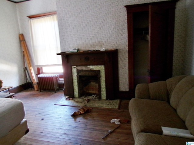 living room featuring a wealth of natural light, radiator heating unit, and light wood-type flooring