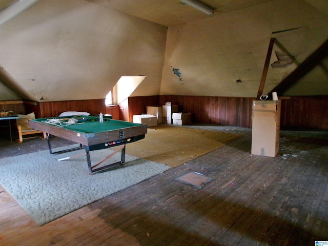 rec room featuring dark hardwood / wood-style flooring, lofted ceiling, and wooden walls