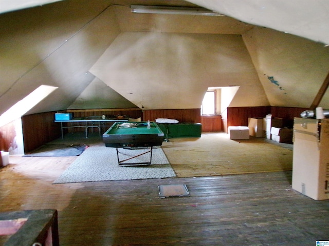 recreation room with hardwood / wood-style flooring, wooden walls, and vaulted ceiling