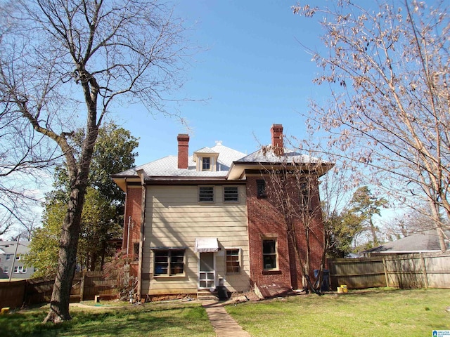 rear view of property featuring a lawn