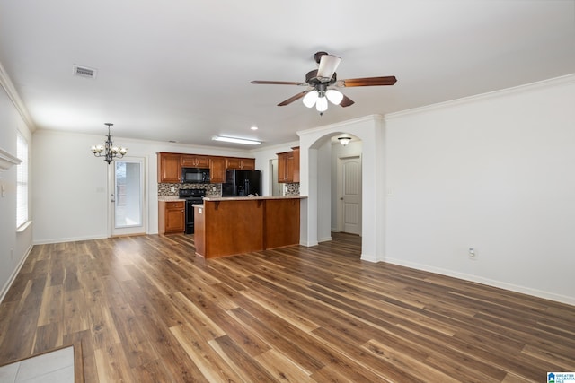 kitchen with crown molding, hanging light fixtures, black appliances, dark hardwood / wood-style flooring, and decorative backsplash