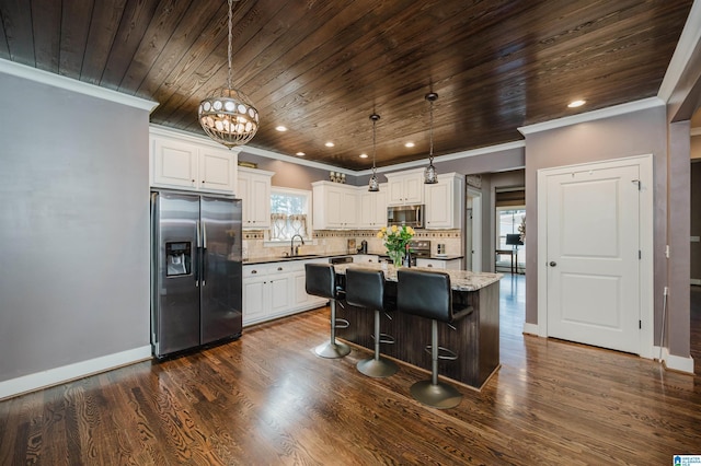 kitchen featuring stainless steel appliances, white cabinetry, a center island, and light stone counters