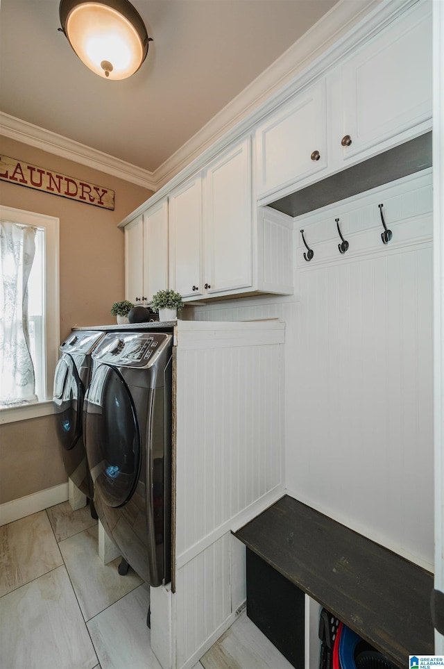 washroom with cabinets, ornamental molding, and independent washer and dryer