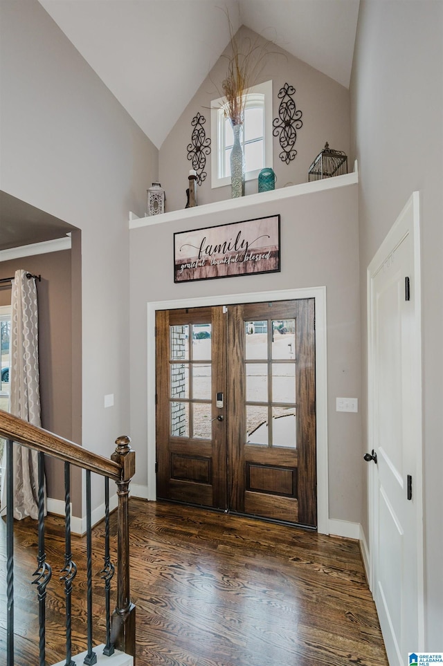 foyer entrance featuring dark wood-type flooring, high vaulted ceiling, and french doors