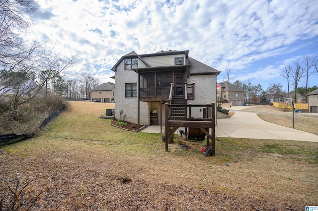 view of front facade featuring a patio area, a front lawn, a sunroom, and cooling unit