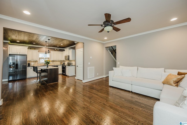 living room featuring dark hardwood / wood-style flooring, ornamental molding, wooden ceiling, and ceiling fan