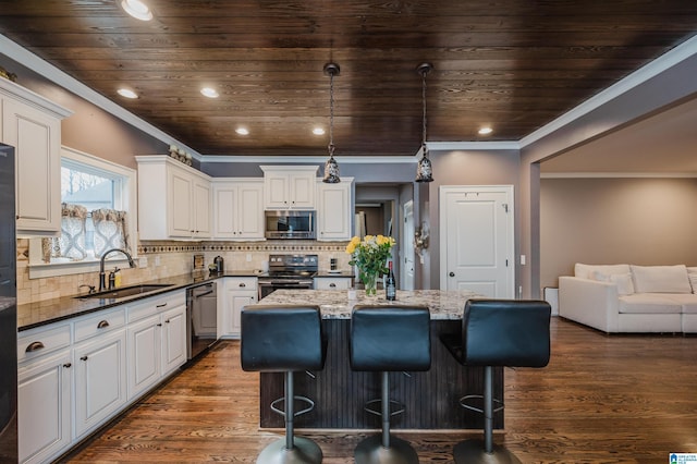 kitchen featuring sink, a center island, dark stone countertops, appliances with stainless steel finishes, and white cabinets