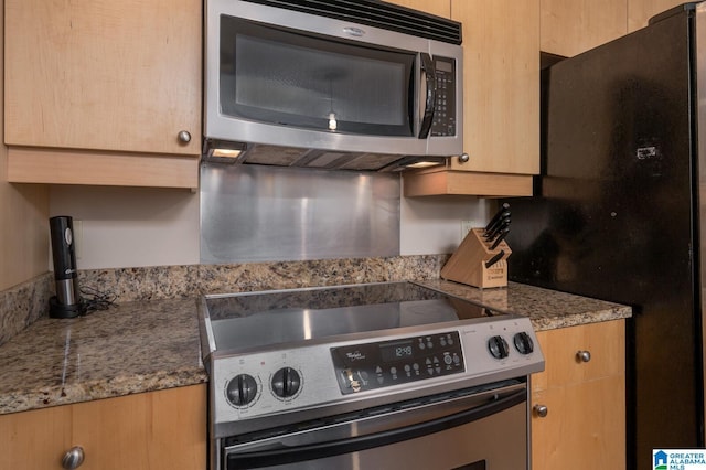 kitchen with appliances with stainless steel finishes, brown cabinets, and dark stone countertops