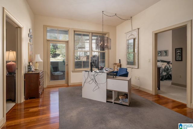 office space featuring a chandelier, baseboards, and wood finished floors